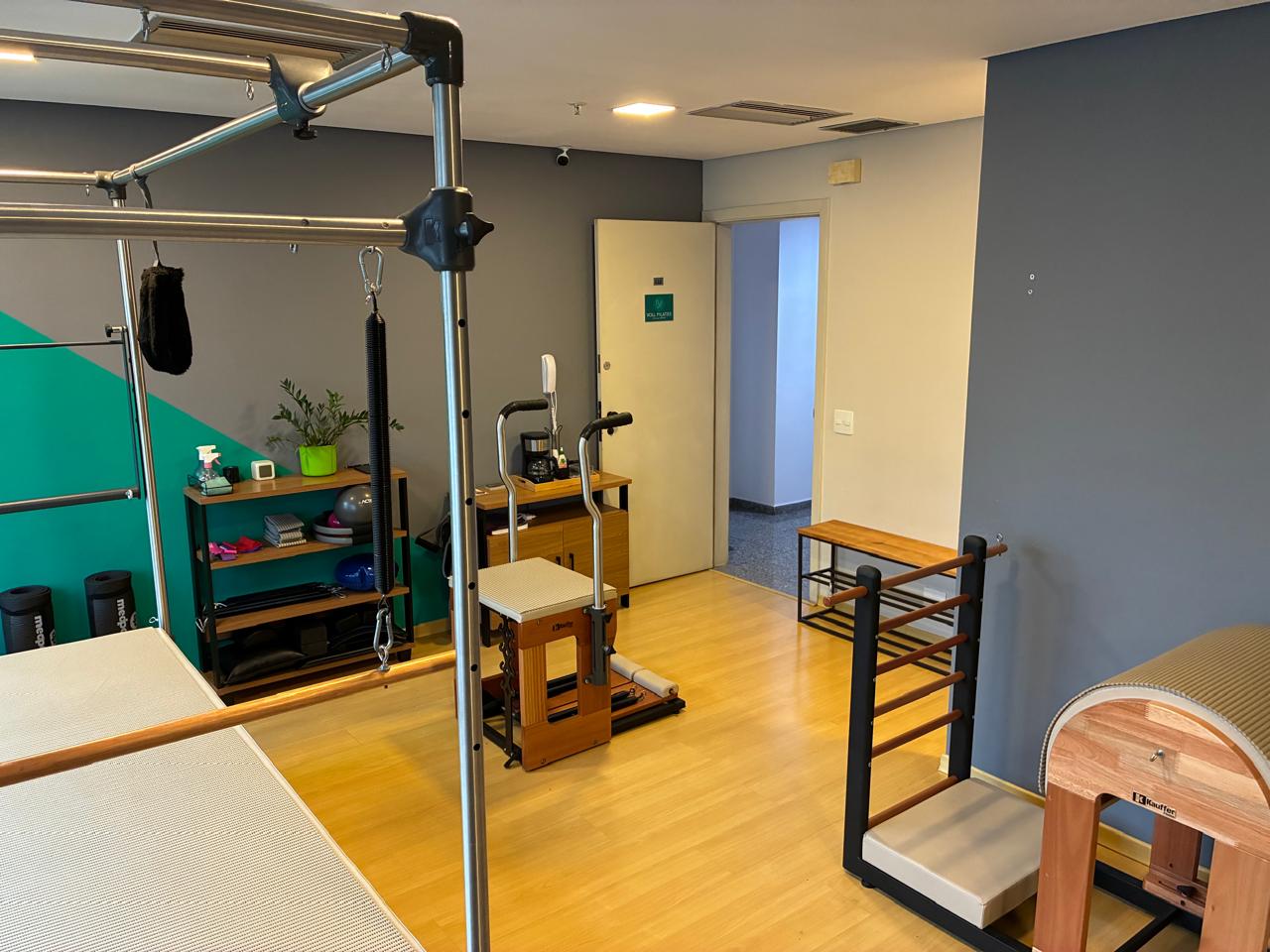 Ambiente do estúdio Voll Pilates Perdizes com parede verde e aparelhos completos